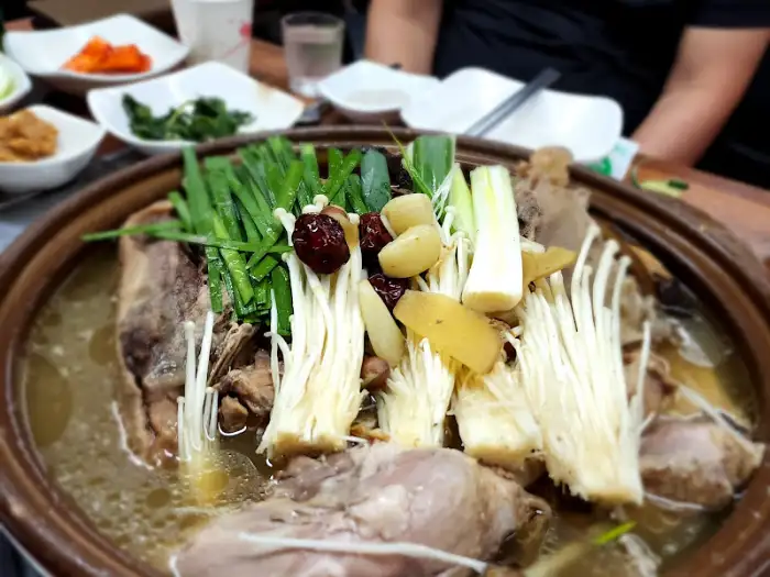 상황한방백숙의 육질과 채소, 그리고 오리발이 돋보이는 클로즈업