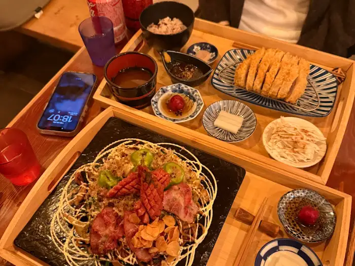 정갈하게 차려진 돈까스와 곁들임 메뉴. 밥과 국물, 샐러드 등이 보인다.
