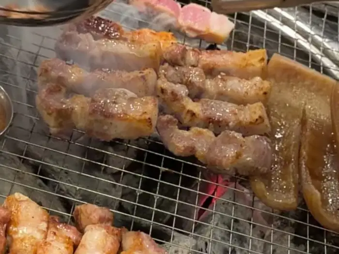 숯불 위에서 지글지글 익어가는 삼겹살과 목살