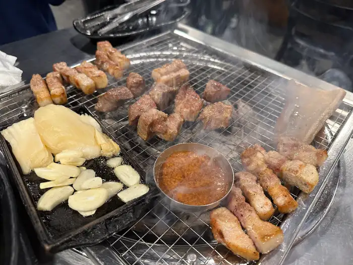 다양한 부위의 고기가 숯불 위에서 맛있게 구워지고 있습니다.
