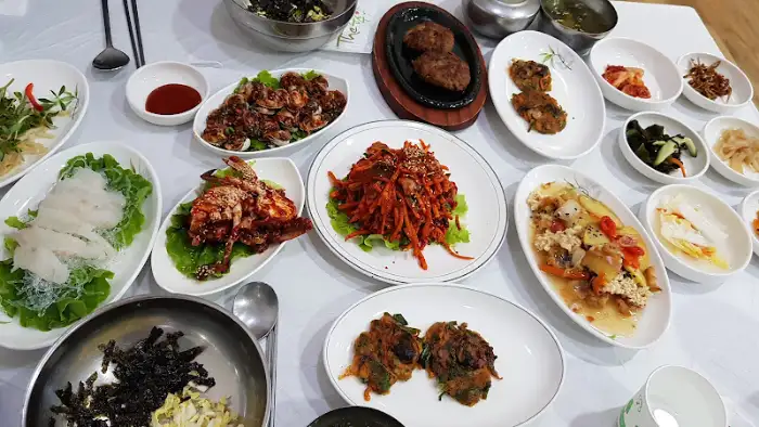 다양한 종류의 밑반찬과 메인 요리가 차려진 테이블