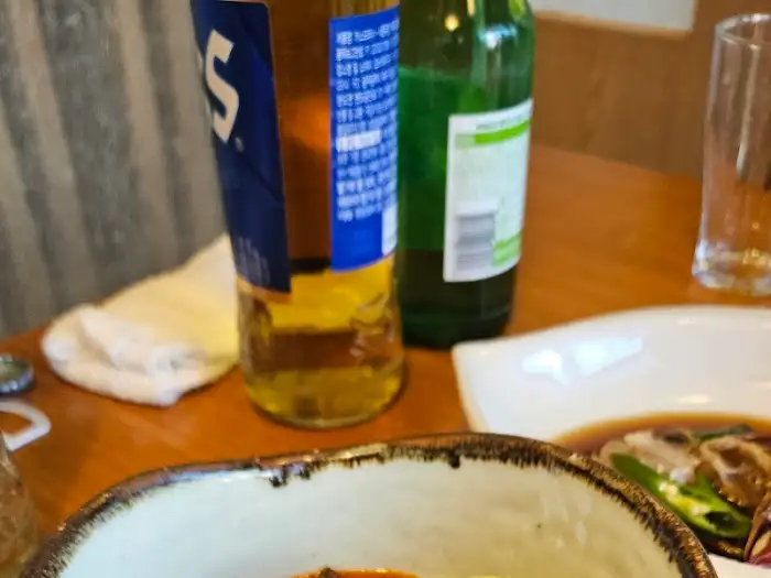 맥주 병과 잔, 그리고 음식 일부