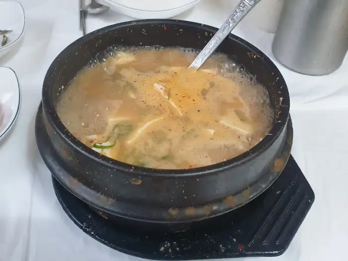 청국장 뚝배기에 숟가락이 담겨 있는 모습