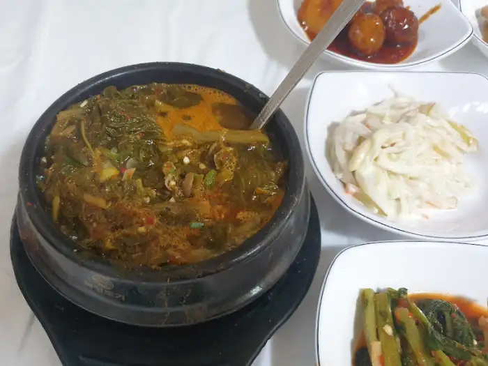 시래기 찌개가 담긴 뚝배기와 몇 가지 밑반찬이 함께 나온 모습
