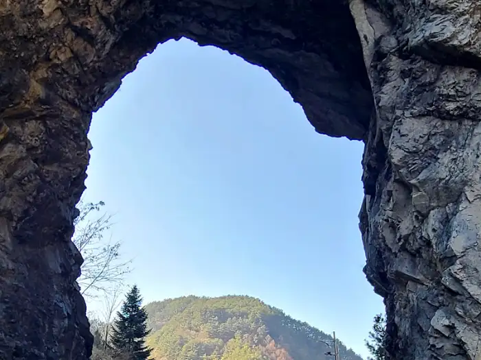 산과 하늘을 배경으로 한 거대한 바위 아치
