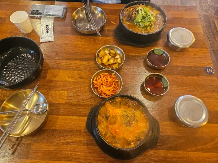 테이블에 차려진 푸짐한 한상차림, 뼈해장국과 밑반찬들