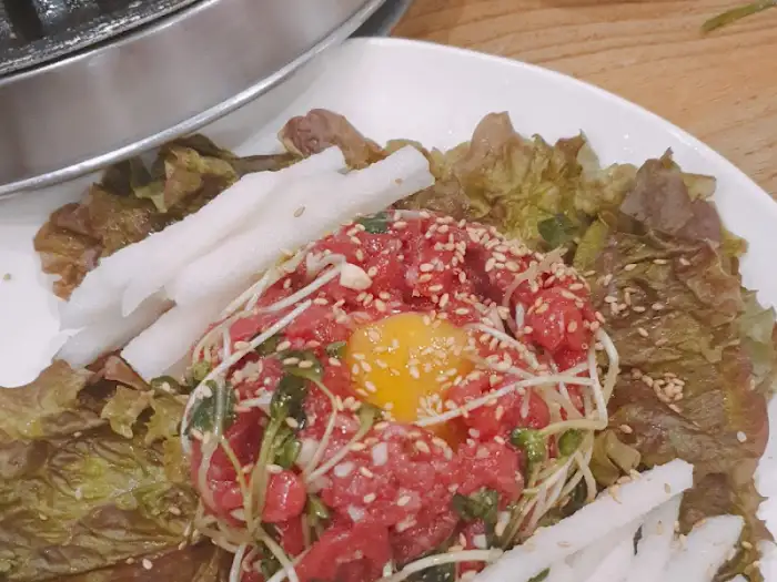 풍년집 정육식당 작전점의 붉은 육회와 신선한 채소