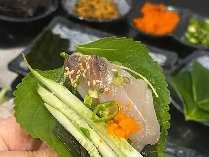 깻잎 위에 막회, 채소, 날치알 등을 올려 만든 쌈