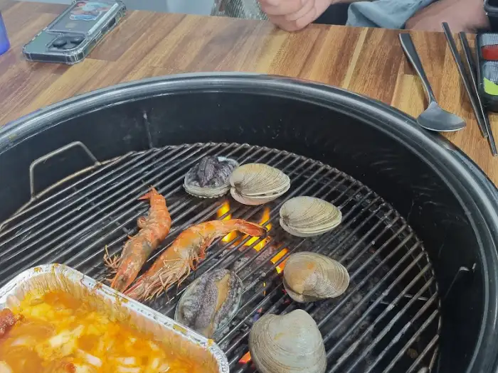 숯불 위에서 익어가는 싱싱한 새우와 조개