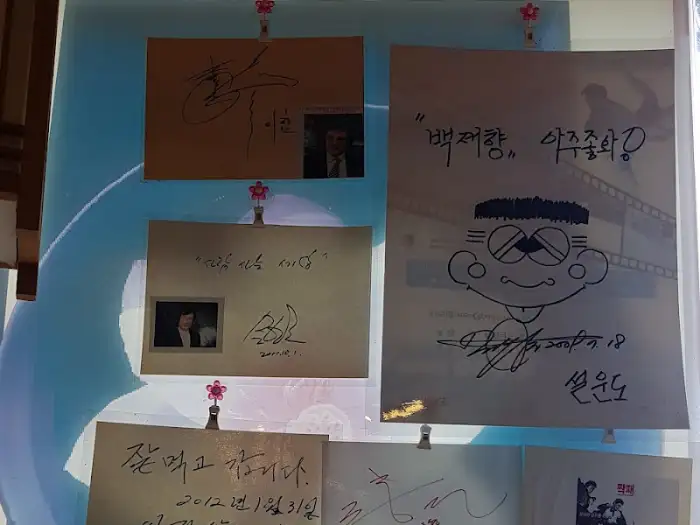 벽면에 걸린 사인과 손글씨 족자