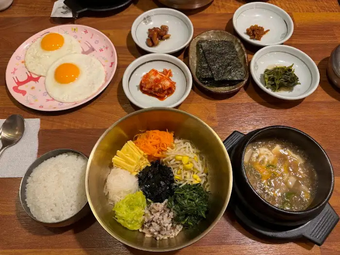 비빔밥 재료와 계란 프라이, 밥, 국이 함께 나온 모습