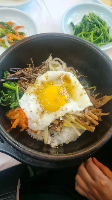 다채로운 나물과 계란 프라이가 올라간 돌솥 비빔밥
