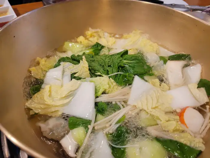 끓고 있는 육수에 채소가 가득 담겨 있습니다.