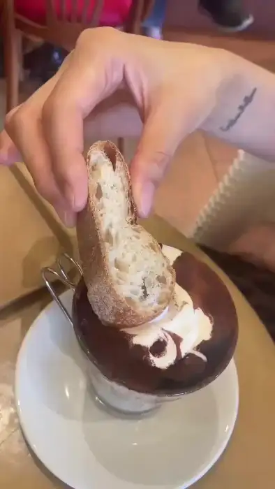 바게트 빵을 커피에 찍어 먹는 손