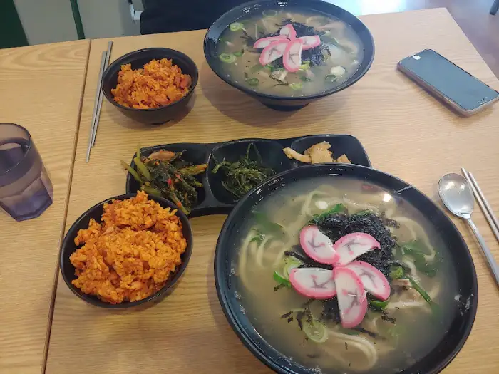두 그릇의 탕과 밥, 그리고 반찬이 놓인 테이블