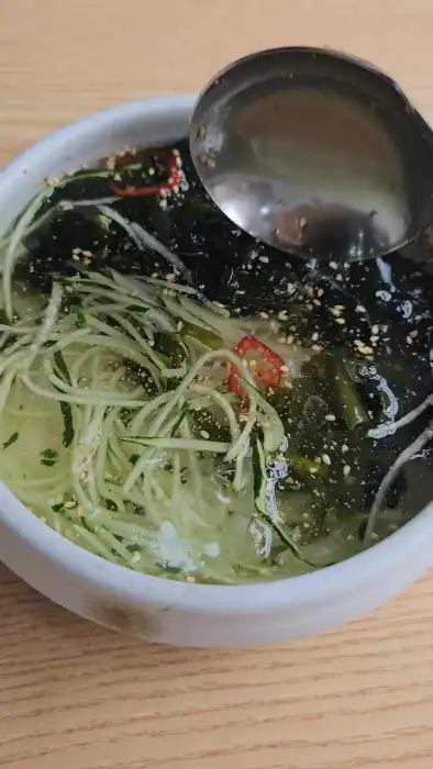시원하고 새콤한 맛이 느껴지는 오이냉국. 얇게 썰어진 오이와 해초가 시각적인 시원함을 더한다.