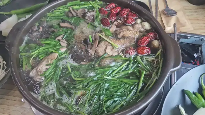 다양한 채소와 약재가 함께 끓고 있는 백숙의 모습