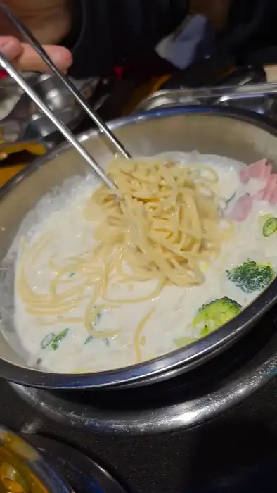 크림 파스타에 면을 돌돌 말아 올리고 있는 모습