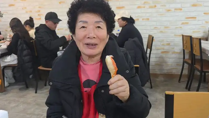 대게를 들고 만족스러운 표정을 짓고 있는 여성