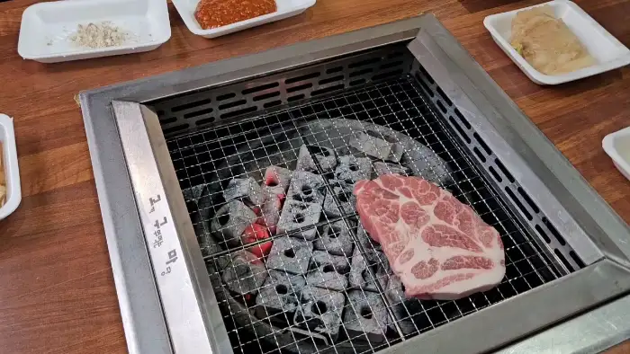 숯불 위에서 구워지고 있는 고기 덩어리