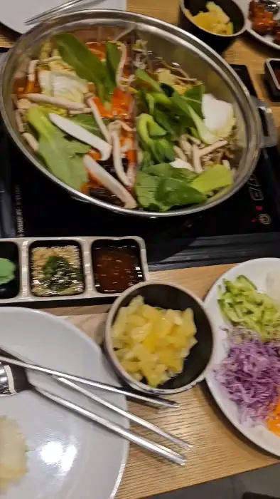 샤브샤브 냄비 속 신선한 채소와 육류가 끓고 있는 모습