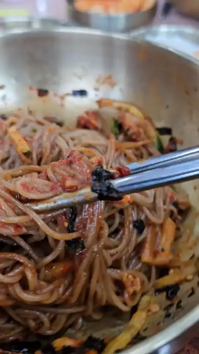젓가락으로 집어 올린 비빔막국수 면발