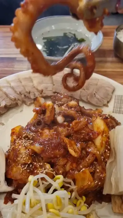 보쌈 위에 낙지볶음을 올리는 모습