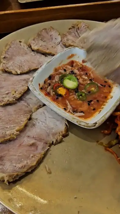 부드러운 수육 한 점과 곁들여 먹는 소스