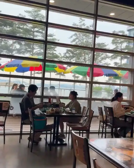 창가 자리에 앉아 식사하는 사람들