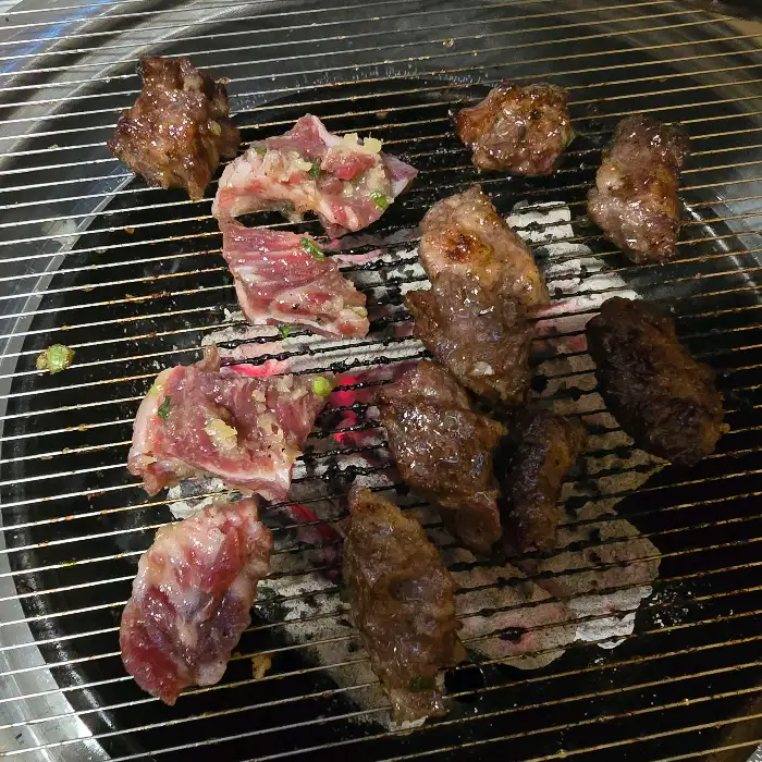 다양한 부위의 소갈비가 숯불 위에서 구워지고 있는 모습