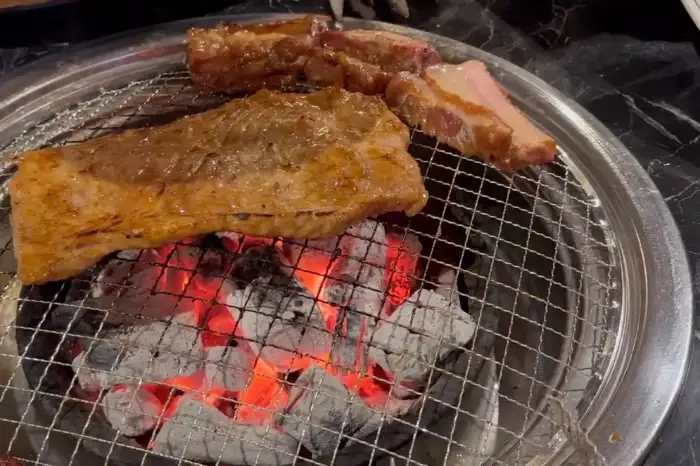 숯불 위에서 익어가는 돼지갈비와 소생갈비