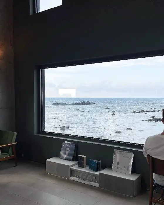 창문 너머로 보이는 바다 풍경과 실내 장식품들