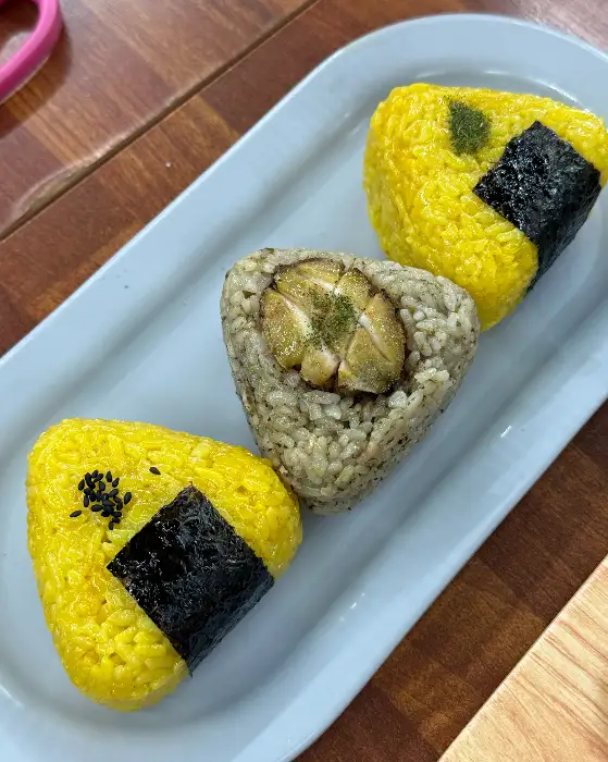 세 가지 모양의 주먹밥이 접시에 담겨 나온 모습. 알록달록한 색감이 시선을 끈다.