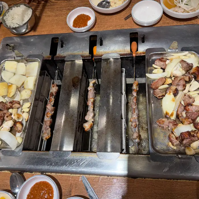 회전 그릴에 익어가는 오리고기 꼬치들