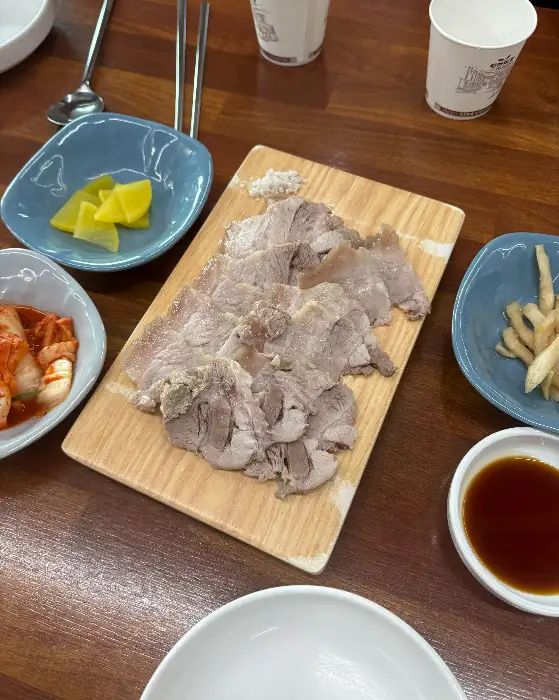 나무 도마 위에 가지런히 담긴 수육. 살코기와 지방의 비율이 적절해 보인다.