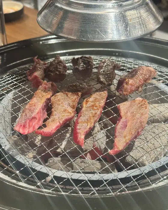 화로 위에서 익고 있는 다양한 소고기 조각들