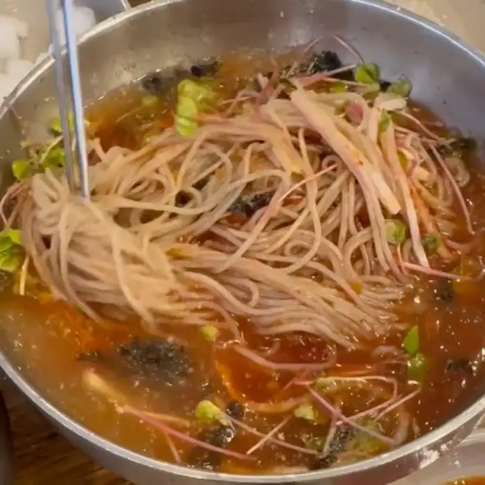 시원한 육수에 담긴 메밀 막국수와 고명