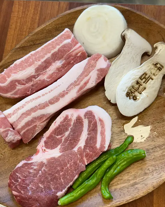접시에 담긴 삼겹살, 목살, 새송이버섯, 양파