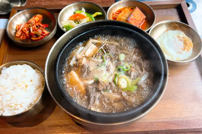정갈하게 차려진 밑반찬과 밥, 그리고 뚝배기 요리