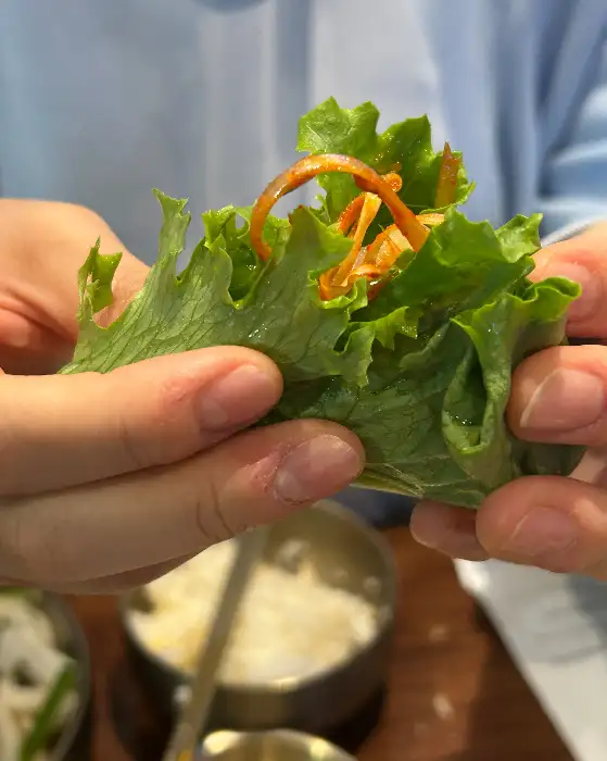 손으로 쌈을 싸고 있는 모습