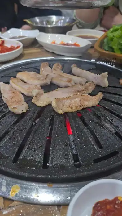 숯불 위에서 구워지고 있는 돼지고기 목살