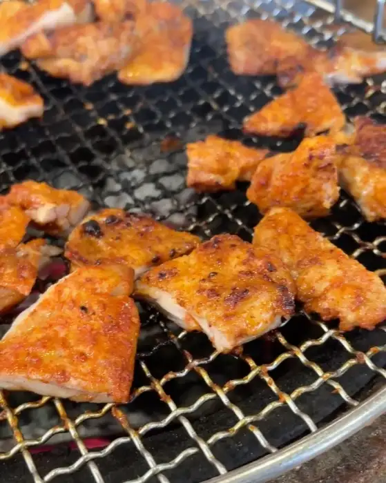 숯불에 구워지고 있는 여러 조각의 닭갈비