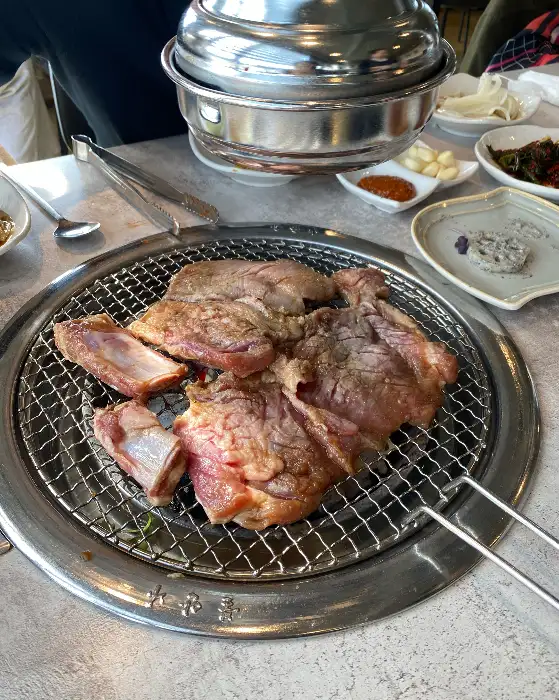 신선한 갈비가 숯불 위에서 맛있게 구워지고 있는 모습