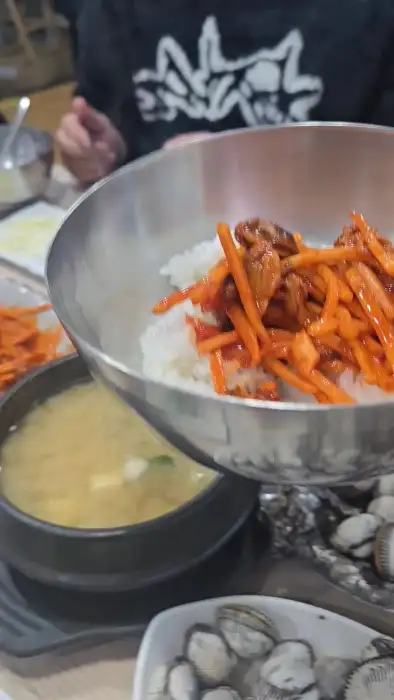 밥과 꼬막무침을 비비는 모습