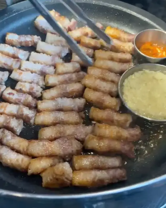 직원이 능숙하게 삼겹살을 굽고 있는 모습