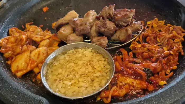 잘 구워진 삼겹살 조각과 곁들임 재료