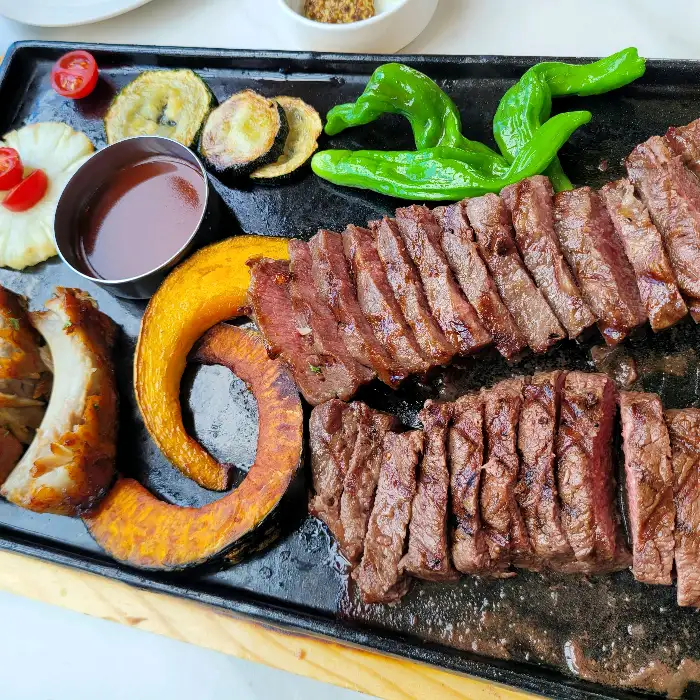 다양한 구운 채소와 함께 제공되는 스테이크