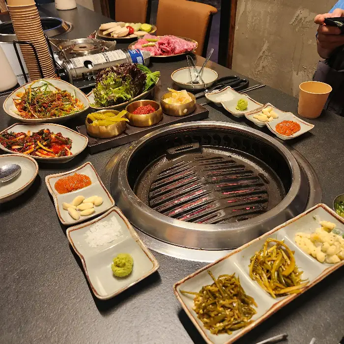 다양한 밑반찬과 불판이 세팅된 테이블 모습