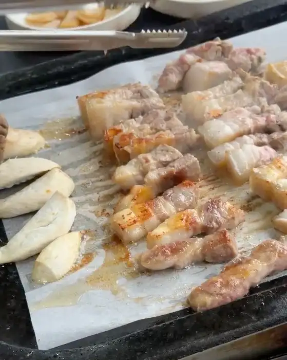 직원이 흑돼지를 맛있게 굽는 모습