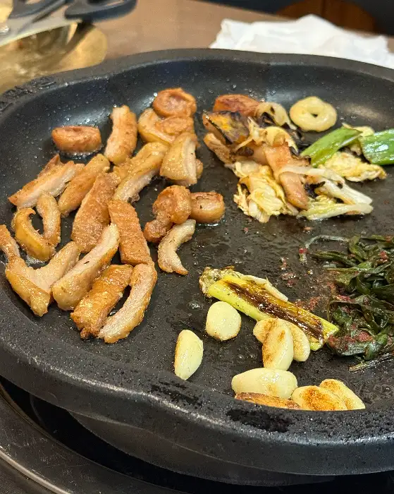 막창과 함께 구워지고 있는 마늘, 파, 깻잎 등의 채소